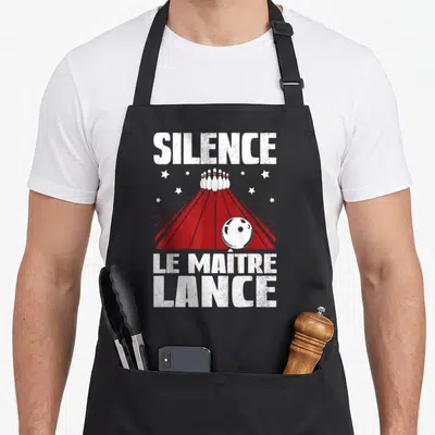 Tablier de cuisine noir avec inscription Silence Le Maître Lance et illustration d'une piste de bowling rouge.
