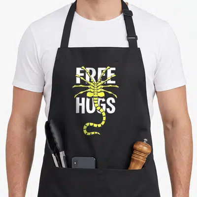 Tablier de cuisine noir avec un alien jaune Free Hugs aux pattes acérées