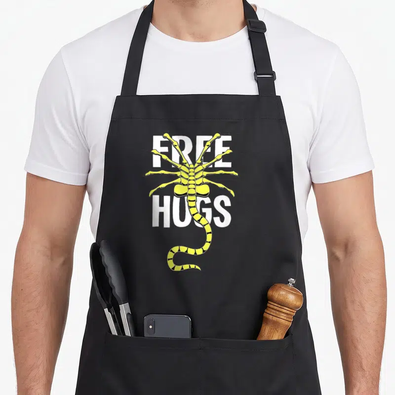 Tablier de cuisine noir avec un alien jaune Free Hugs aux pattes acérées
