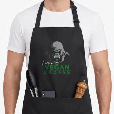 Tablier de cuisine noir avec illustration de gorille vert et texte I'm a VEGAN BADASS imprimé au centre.