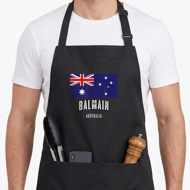 Tablier de cuisine noir avec drapeau australien et texte Balmain Australia en blanc usé.
