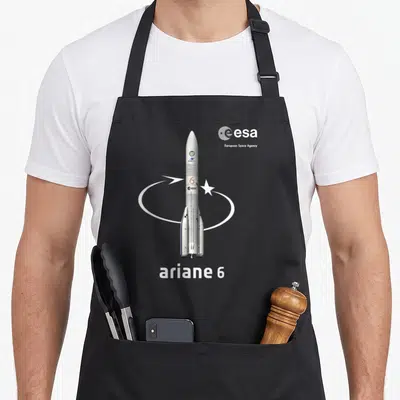 Tablier de cuisine noir avec une illustration détaillée de la fusée Ariane 6 et le logo de l'ESA en haut à droite.