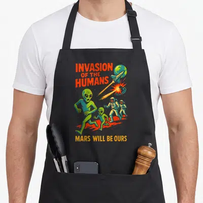 Tablier de cuisine noir avec illustration d'aliens verts et d'astronautes sous le texte Invasion of the Humans.