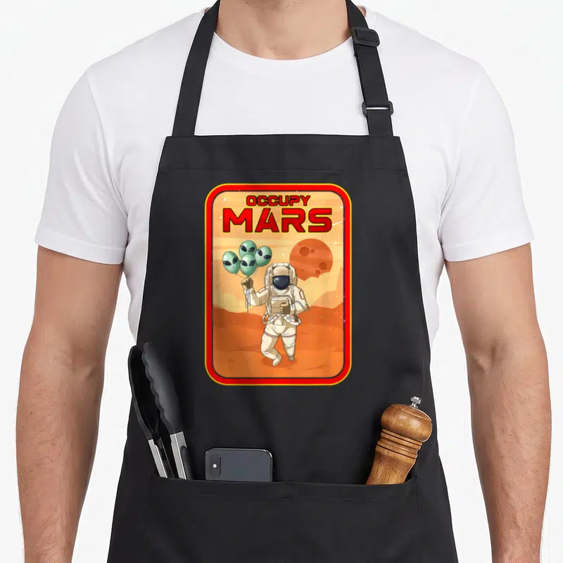 Tablier de cuisine noir avec illustration d'un astroaut tenant des ballons aliens sous le texte Occupy Mars.