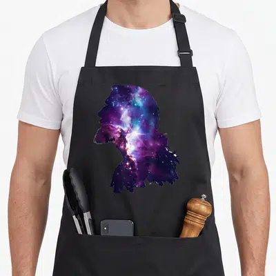 Tablier de cuisine noir avec silhouette de profil remplie d'une galaxie violette et bleue évoquant la Voie lactée et des étoiles scintillantes.