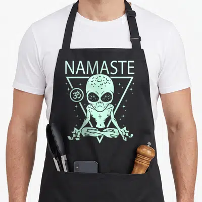 Tablier de cuisine noir avec alien en méditation, texte Namaste et symbole Om dans un triangle mint.