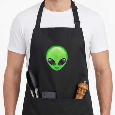 Tablier de cuisine noir avec tête d'alien vert aux grands yeux noirs et sourire discret
