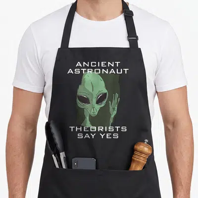 Tablier de cuisine noir avec une illustration d'extraterrestre vert et du texte blanc sur fond sombre.