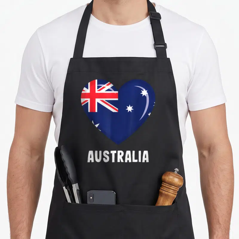 Tablier de cuisine noir avec un grand cœur affichant le drapeau Australie et le mot AUSTRALIA en lettres blanches en dessous.