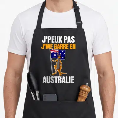 Tablier de cuisine noir avec un kangouron portant des lunettes de soleil et brandissant le drapeau australien sous un texte humoristique.