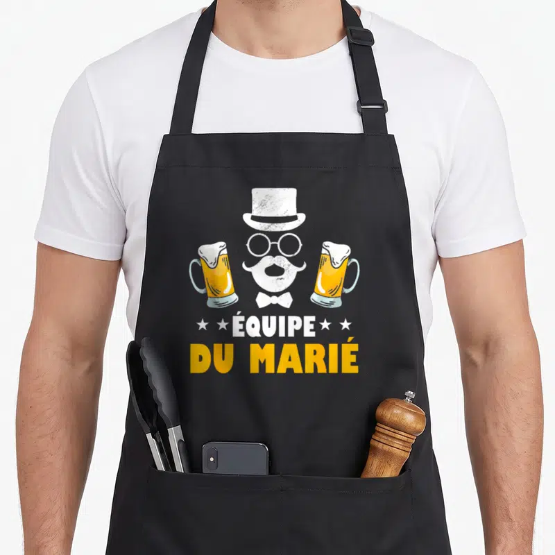 Tablier de cuisine noir avec illustration d'une équipe du marié coiffée d'un chapeau haut de forme flanquée de deux bières.