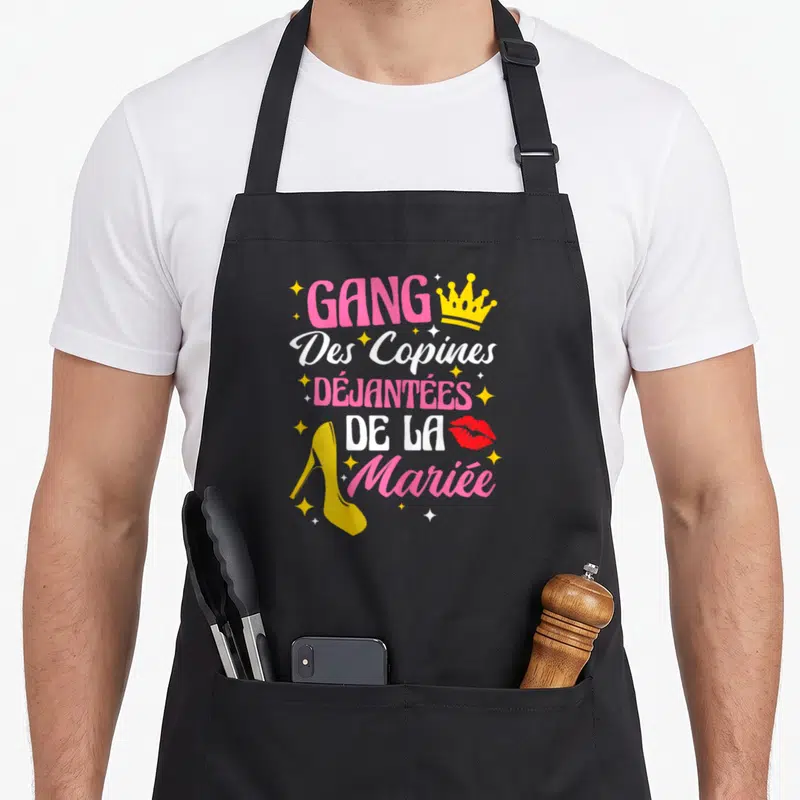 Tablier de cuisine noir avec inscription gang des copines déjantées de la mariée, talon jaune et crown doré.