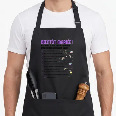 Tablier de cuisine noir avec texte bientôt mariée et liste de défis illustrés par licorne et cocktails colorés.