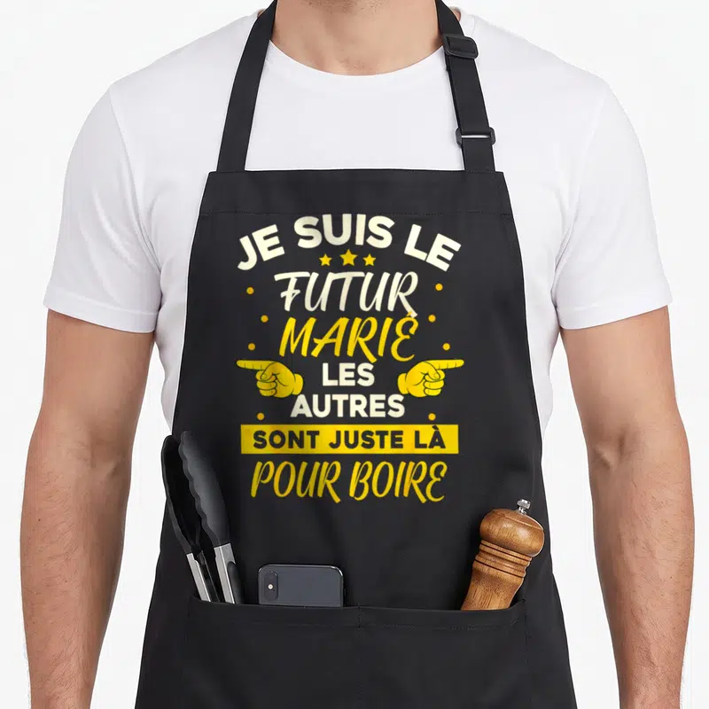 Tablier de cuisine noir avec l'inscription Je suis le futur marié les autres sont juste là pour boire en jaune et blanc.
