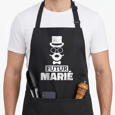Tablier de cuisine noir avec illustration blanche d'un futur marié coiffé d'un chapeau haut de forme et d'une moustache.