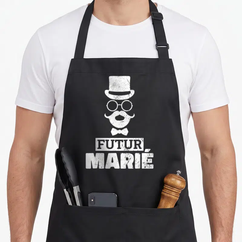 Tablier de cuisine noir avec illustration blanche d'un futur marié coiffé d'un chapeau haut de forme et d'une moustache.