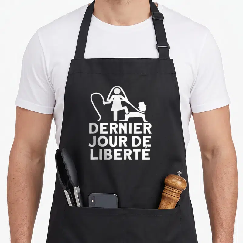 Tablier de cuisine noir avec inscription blanc dernier jour de liberté et silhouette femme menottant homme chapeau haut de forme
