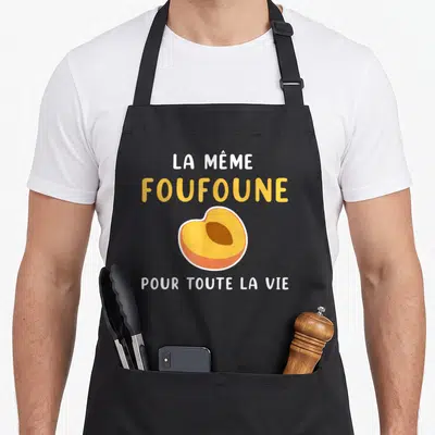 Tablier de cuisine noir avec inscription La même foufoune pour toute la vie et un dessin d'abricot jaune et orange.