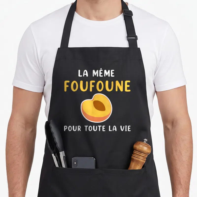 Tablier de cuisine noir avec inscription La même foufoune pour toute la vie et un dessin d'abricot jaune et orange.