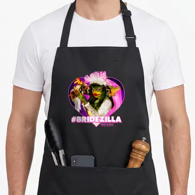 Tablier de cuisine noir avec une illustration colorée d'une créature verte en tenue de mariée et le texte #BRIDEZILLA en bas.
