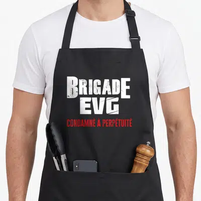 Tablier de cuisine noir avec inscription blanche Brigade EVG et rouge condamné à perpétuité en typographie style pochoir.
