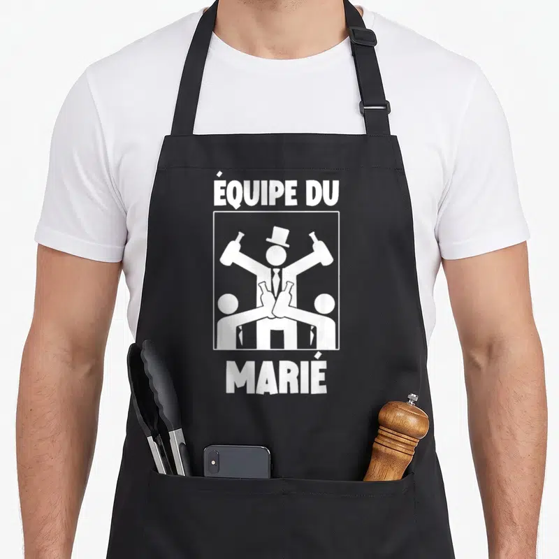 Tablier de cuisine noir avec illustration blanche Équipe du Marié et silhouettes festives.