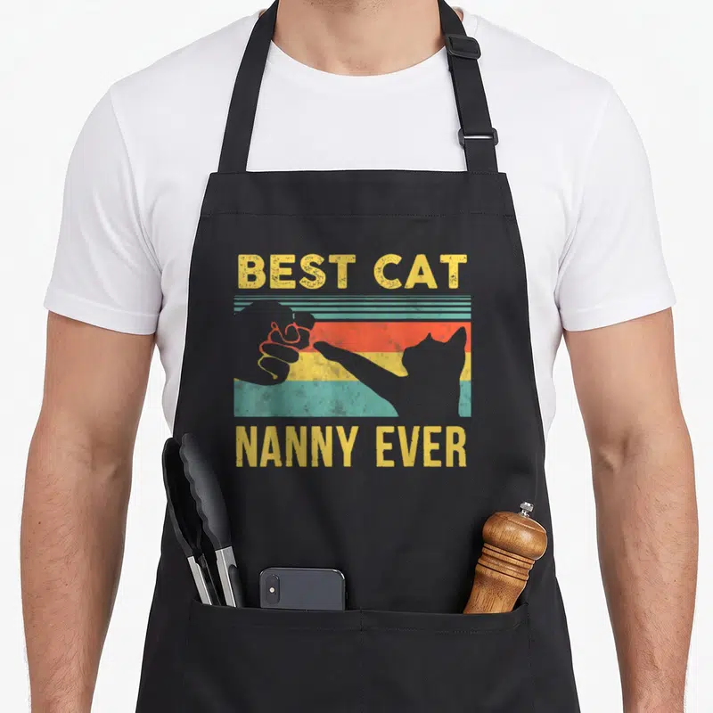Tablier de cuisine noir avec illustration vintage montrant une main et un chat en high five sur fond rayé.