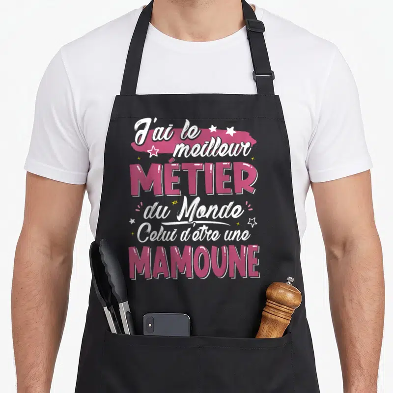Tablier de cuisine noir avec inscription rose et blanche célébrant le métier de mamoune entouré d'étoiles.