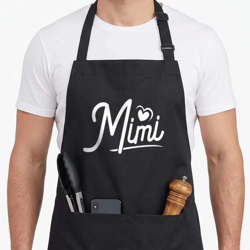 Tablier de cuisine noir avec l'inscription Mimi en blanc et un cœur au-dessus du i.