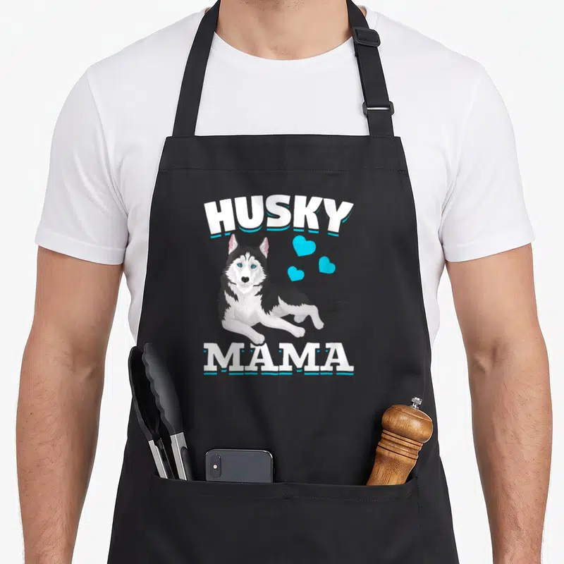 Tablier de cuisine noir avec illustration d'un husky et le texte Husky Mama en blanc et bleu.