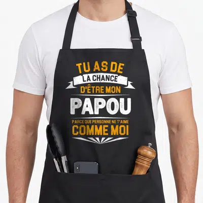 Tablier de cuisine noir avec le texte Tu as de la chance d'être mon papou en orange et blanc.