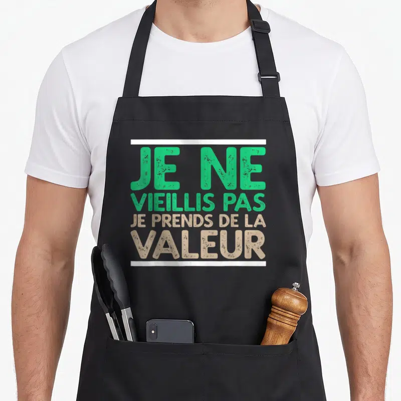 Tablier de cuisine noir avec inscription Je ne vieillis pas je prends de la valeur en vert et beige.