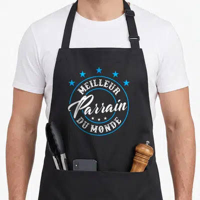 Tablier de cuisine noir avec linscription Meilleur Parrain du Monde entouré d'étoiles bleues en cercle.