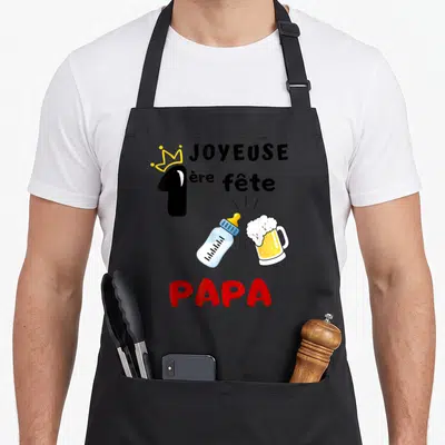 Tablier de cuisine noir avec inscription Joyeuse 1ère fête Papa et illustration biberon bière.