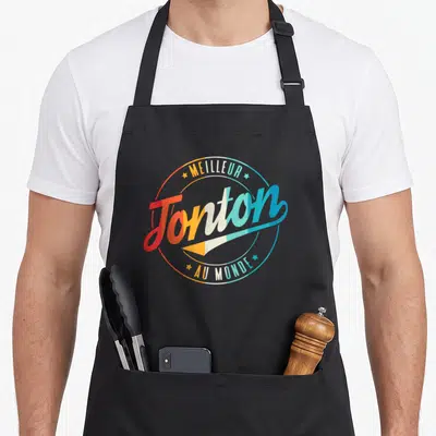 Tablier de cuisine noir avec logo circulaire Meilleur Tonton au Monde aux couleurs vives.