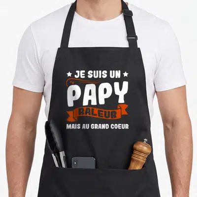 Tablier de cuisine noir avec le texte blanc et orange Je Suis Un Papy Raleur Mais Au Grand Coeur.