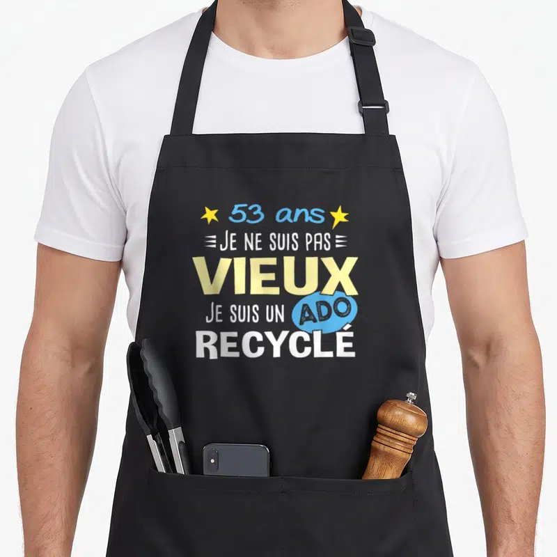 Tablier de cuisine noir avec inscription 53 ans je ne suis pas vieux je suis un ado recyclé et étoiles jaunes.
