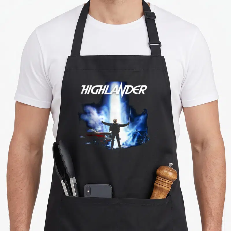Tablier de cuisine noir avec le titre Highlander et un personnage tenant une épée entre une voiture et une moto.