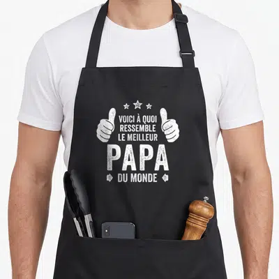 Tablier de cuisine noir avec deux mains en signe d'approbation et texte blanc celebrating le meilleur papa du monde.