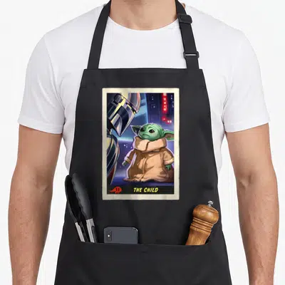 Tablier de cuisine noir avec illustration du Mandalorian et Grogu The Child en carte vintage sur fond urbain bleu et rouge.
