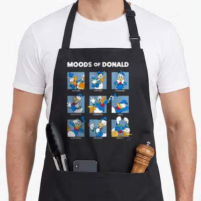 Tablier de cuisine noir avec une grille de neuf illustrations de Donald Duck représentant divers états d'âme sous le titre Moods of Donald.
