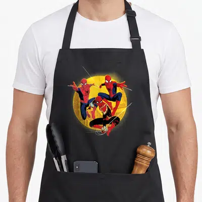 Tablier de cuisine noir avec trois Spider-Man en action sur un cercle jaune lumineux.