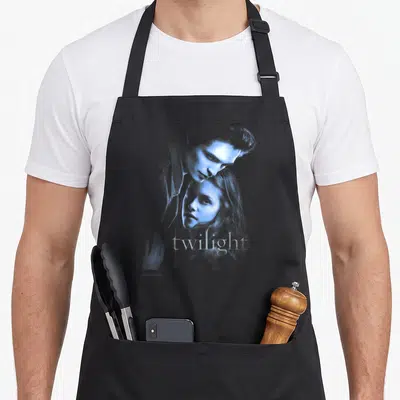Tablier de cuisine noir avec illustration bleue d'un couple et le mot twilight en typographie stylisée.