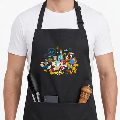 Tablier de cuisine noir avec Mickey, Minnie, Donald, Goofy, Pluto, le château et l'inscription 50 ans Walt Disney World.