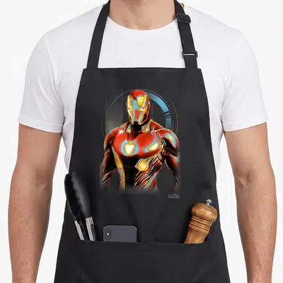 Tablier de cuisine noir avec illustration d'Iron Man en armure rouge et dorée sur fond gris uni.