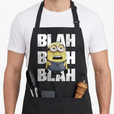Tablier de cuisine noir avec un Minion jaune aux yeux mi-clos et le texte BLAH répété en lettres blanches derrière lui.