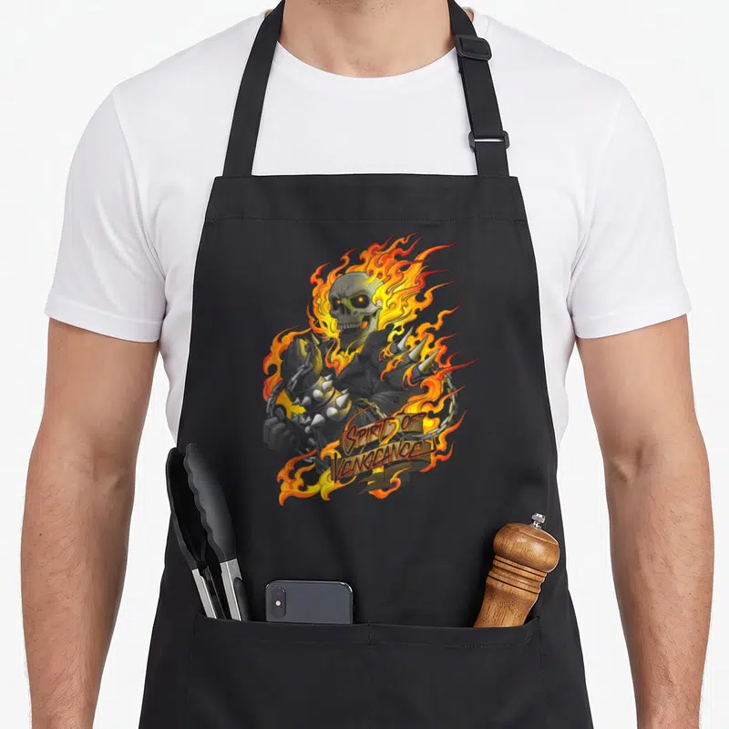 Tablier de cuisine noir avec un crâne enflammé et l'inscription Spirit of Vengeance en lettres dorées stylisées.