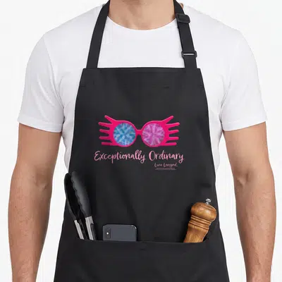 Tablier de cuisine noir avec lunettes roses à verres géométriques bleus et violets et texte Exceptionally Ordinary Luna Lovegood