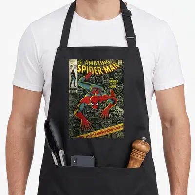Tablier de cuisine noir avec la couverture colorée du 100e numéro d'« Amazing Spider-Man » et ses ennemis en arrière-plan.