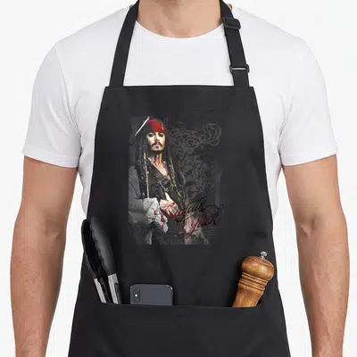 Tablier de cuisine noir avec illustration du capitaine Jack et calligraphie rouge élégante.